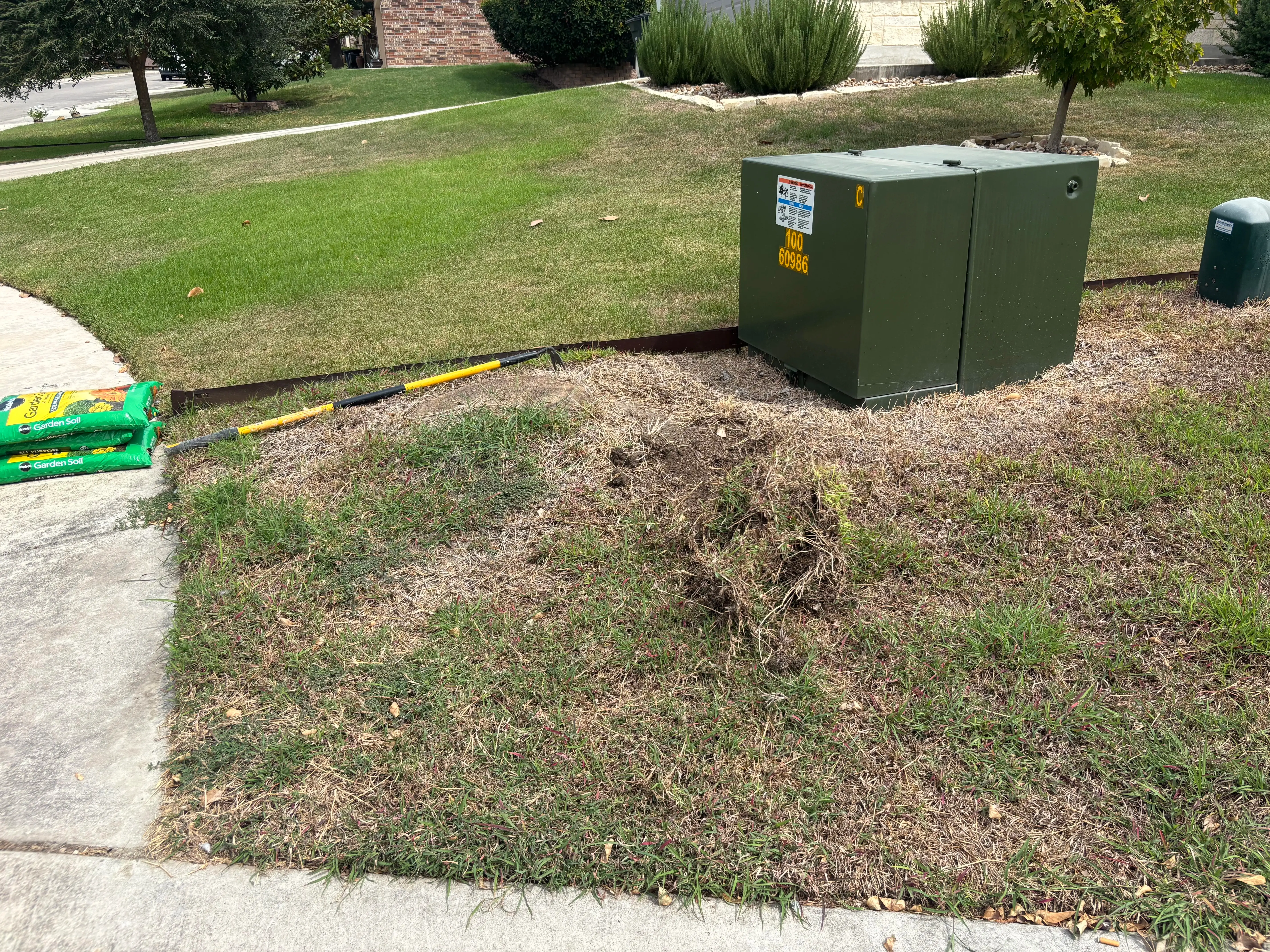 Grassy patch besides a sidewalk before a project.