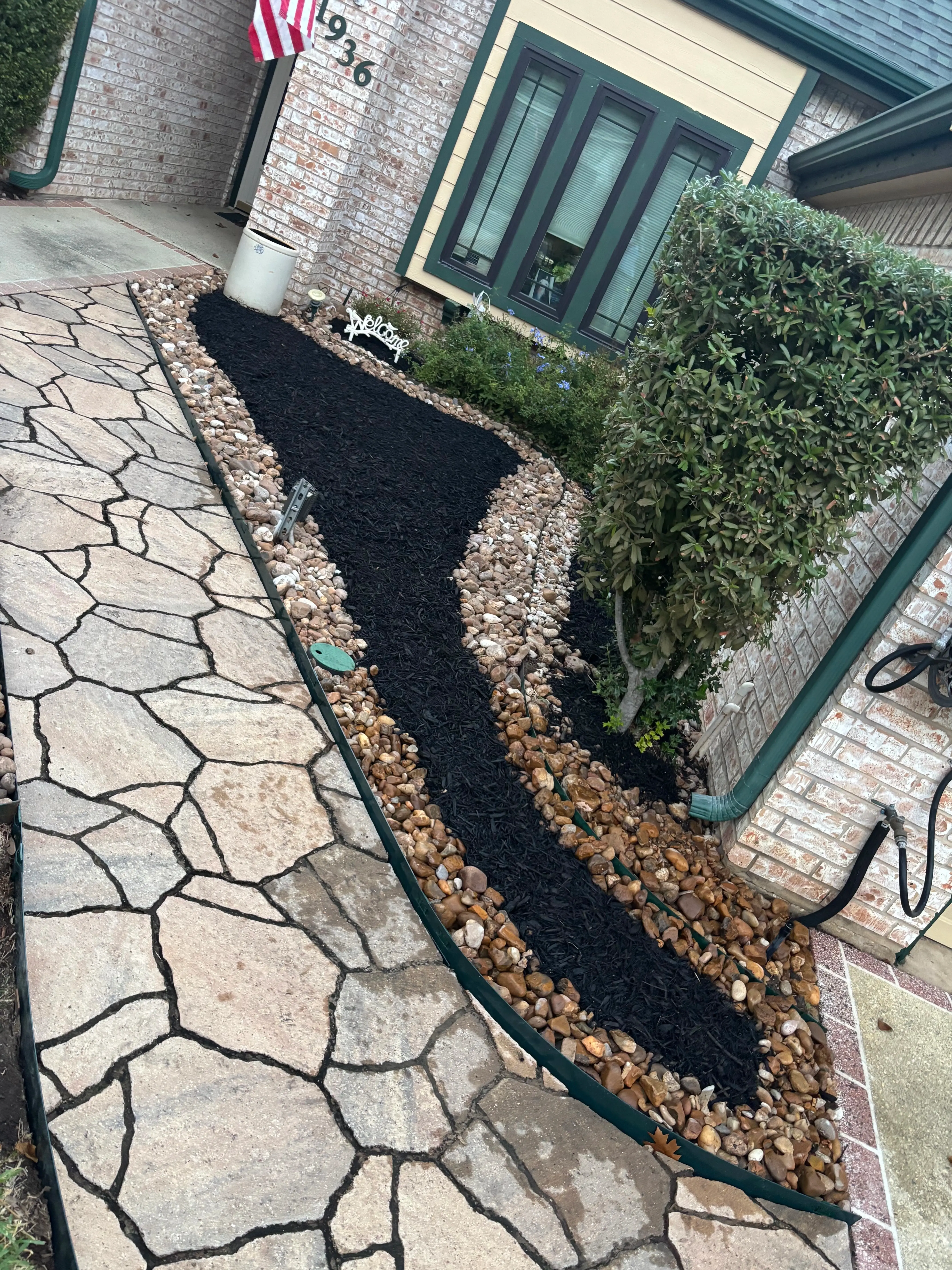 Front yard entryway with mulch and decorative rocks